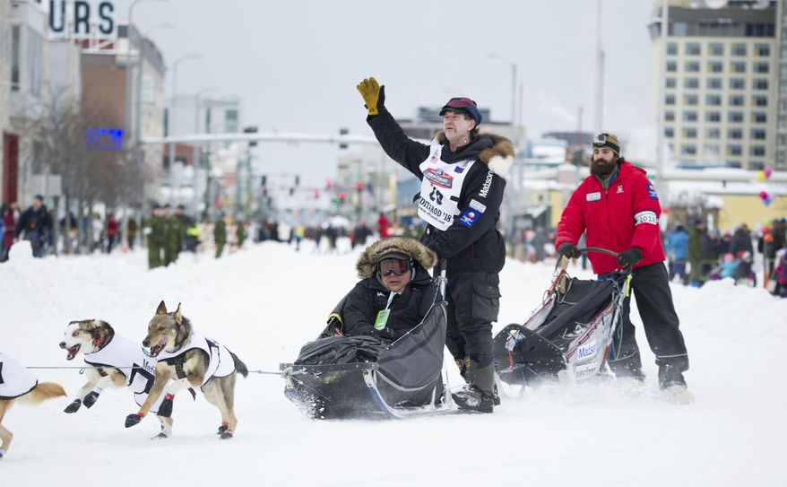 Iditarod musher Allen Moore waves to the crowd during the ceremonial start of the Iditarod Trail Sled Dog Race, Saturday, March 3, 2018, in Anchorage, Alaska. Moore has just won the Yukon Quest, a dog sled race from Whitehorse, Yukon Territory to Fairbanks, Alaska. (AP Photo/Michael Dinneen)