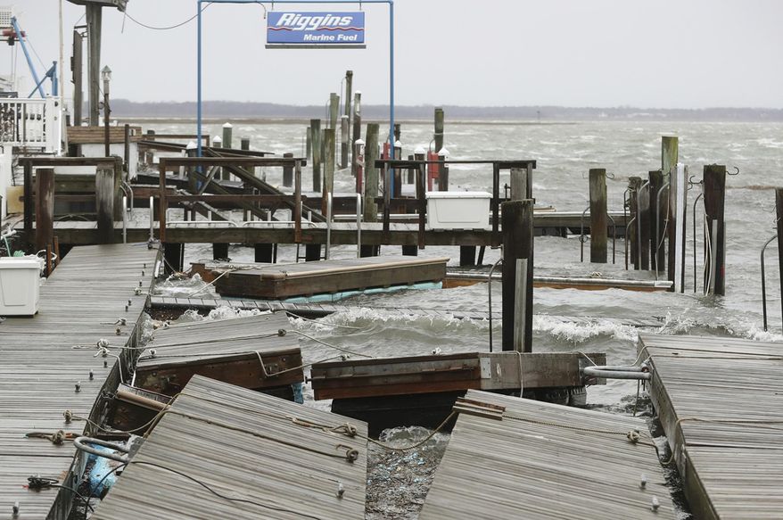 FILE - In this March 2, 2018 file photo, high winds and rough surf toss about the boat docks at Smuggler's Cove in Stone Harbor, N.J. Residents along the Northeast coast braced for more flooding during high tides Saturday even as the powerful storm that inundated roads, snapped trees and knocked out power to more than 2 million homes and businesses moved hundreds of miles out to sea. (Dale Gerhard/The Press of Atlantic City via AP)