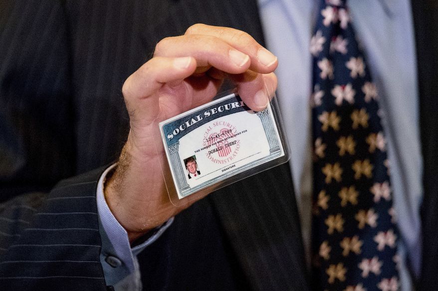 William Wachtel holds up a mock Social Security card of President-elect Donald Trump as he speaks to members of the media following a meeting with Trump at Trump Tower in New York, Monday, Jan. 16, 2017. (AP Photo/Andrew Harnik)