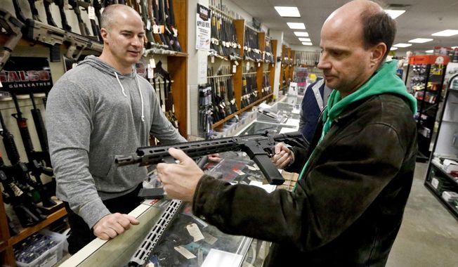 Wes Morosky, owner of Duke&#x27;s Sport Shop. left, helps Ron Detka as he shops for a rifle on Friday, March 2, 2018, at his store in New Castle. (AP Photo/Keith Srakocic) ** FILE **