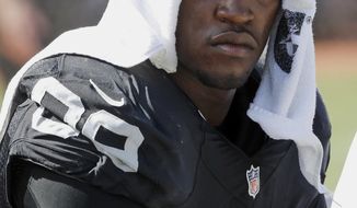 FILE - In this Sept. 20, 2015, file photo, Oakland Raiders&#39; Aldon Smith cools off during an NFL football game against the Baltimore Ravens in Oakland , Calif. Police are searching for suspended Smith, who is suspected of domestic violence. San Francisco police said Sunday, March 4, 2018, that Smith fled a San Francisco home Saturday night after someone called the police to report a domestic violence incident. (AP Photo/Tony Avelar, File)
