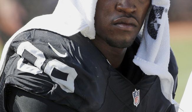 FILE - In this Sept. 20, 2015, file photo, Oakland Raiders&#x27; Aldon Smith cools off during an NFL football game against the Baltimore Ravens in Oakland , Calif. Police are searching for suspended Smith, who is suspected of domestic violence. San Francisco police said Sunday, March 4, 2018, that Smith fled a San Francisco home Saturday night after someone called the police to report a domestic violence incident. (AP Photo/Tony Avelar, File)