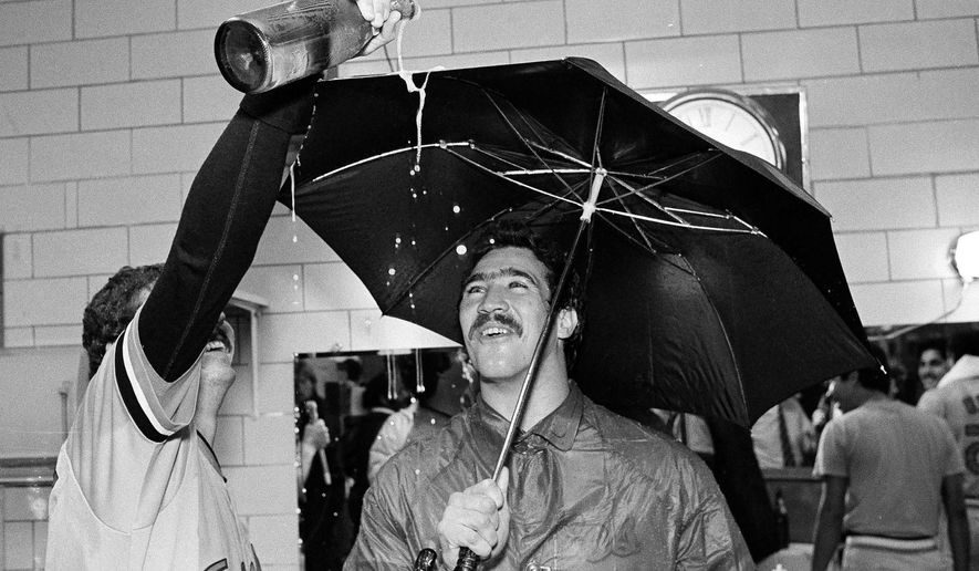 FILE - In this Sept. 25, 1983, file photo, Baltimore Orioles pitcher Sammy Stewart, right, uses an umbrella to keep dry as teammate Bill Swaggerty pours a beverage during their victory celebration after defeating the Milwaukee Brewers to win the American League Eastern Division title in Milwaukee, Wis. Stewart, who helped the Orioles win the 1983 World Series before falling into a life of drug addiction and arrests, has died. He was 63. The Henderson County Sheriff's Office said Stewart was found dead Friday, March 2, 2018, at a residence. No cause for his death had been determined as of Sunday. (AP Photo/Tom Lynn, File)