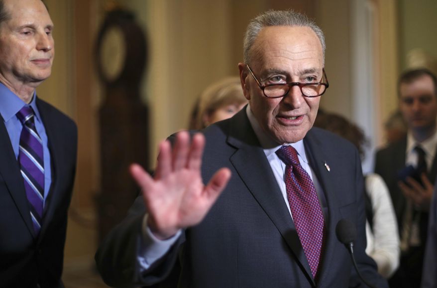 Senate Minority Leader Chuck Schumer of N.Y., right, speaks to reporters following weekly policy luncheons to answer questions on Capitol Hill in Washington, Tuesday, March 6, 2018. Watching is Sen. Ron Wyden, D-Ore., left. The Senate moves closer to passing legislation to roll back some of the safeguards Congress put in place to prevent a repeat of the 2008 financial crisis. (AP Photo/Pablo Martinez Monsivais)
