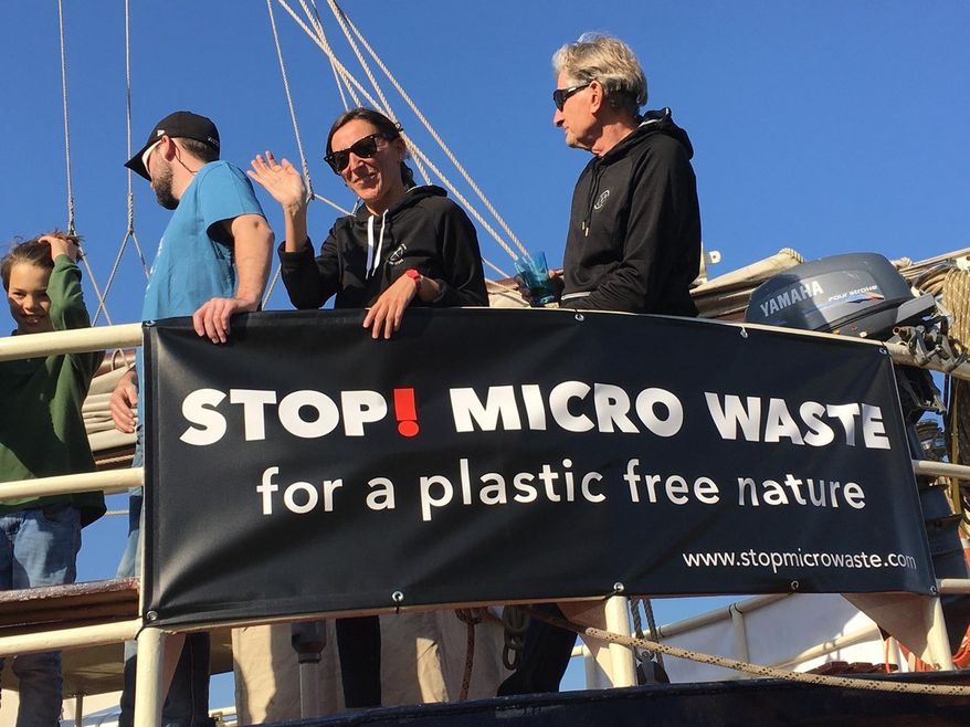 In this Oct. 15, 2017, photo provided by Alexander Nolte, Marta Delgado, center, and Joseph Dillard, right, participate in an event to raise awareness about microfiber pollution in the environment in Amsterdam, Netherlands. Innovators are coming up with new tools to prevent tiny pieces of threads from entering waterways after the laundry and reaching marine life. (Alexander Nolte via AP)