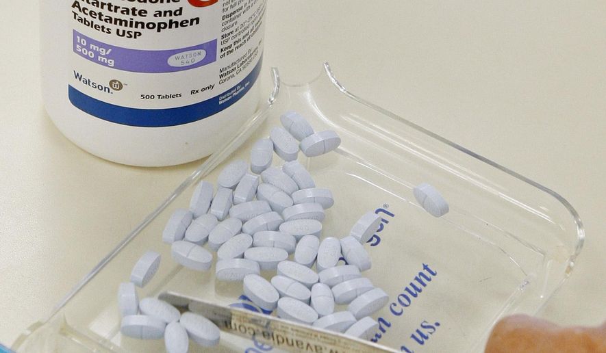 In this Aug. 5, 2010, file photo, a pharmacy technician poses for a picture with hydrocodone and acetaminophen tablets, also known as Vicodin, at the Oklahoma Hospital Discount Pharmacy in Edmond, Okla.  On Wednesday, March 14, an 88-count federal indictment was announced against Pittsburgh radiologist Omar A. Almusa, 45. Dr. Almusa allegedly wrote out prescriptions for the painkiller Vicodin and gave the drug to individuals who had no medicinal need for it. (AP Photo/Sue Ogrocki, File) **FILE**