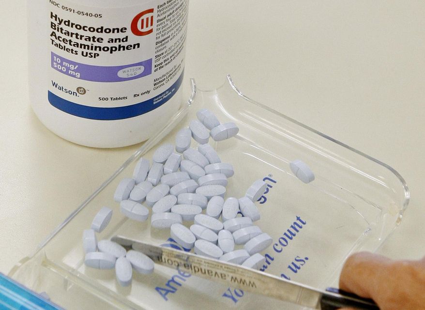 In this Aug. 5, 2010, file photo, a pharmacy technician poses for a picture with hydrocodone and acetaminophen tablets, also known as Vicodin, at the Oklahoma Hospital Discount Pharmacy in Edmond, Okla.  On Wednesday, March 14, an 88-count federal indictment was announced against Pittsburgh radiologist Omar A. Almusa, 45. Dr. Almusa allegedly wrote out prescriptions for the painkiller Vicodin and gave the drug to individuals who had no medicinal need for it. (AP Photo/Sue Ogrocki, File) **FILE**