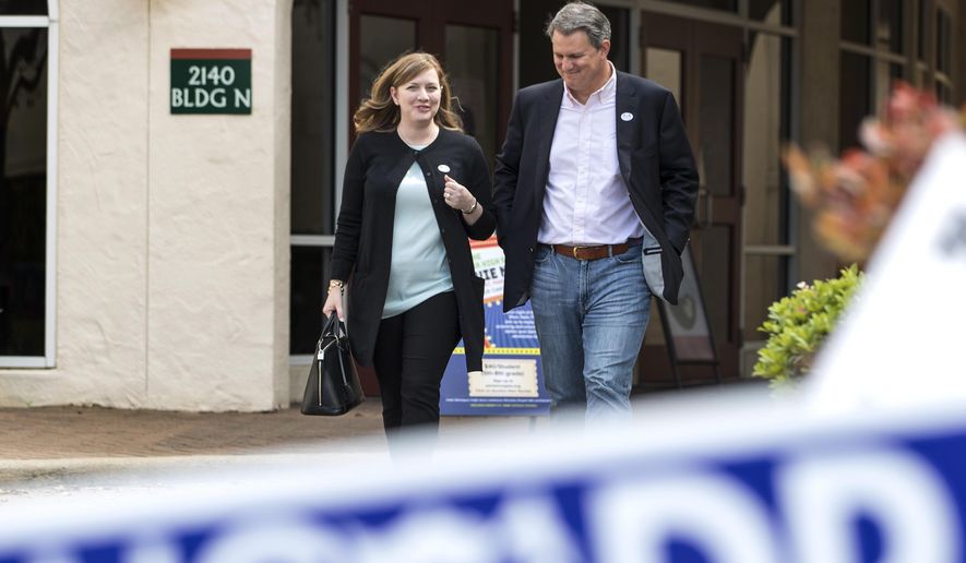 Lizzie Pannill Fletcher, a Democrat running for the 7th Congressional District seat in the U.S. House of Representatives, and her husband, Scott Fletcher, walk out of the polling place at St. Anne's Catholic Church after voting in the primary election on Tuesday, March 6, 2018, in Houston. (Brett Coomer/Houston Chronicle via AP)