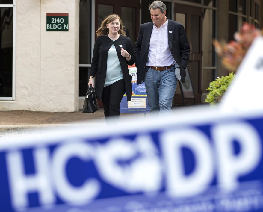 Lizzie Pannill Fletcher, a Democrat running for the 7th Congressional District seat in the U.S. House of Representatives, and her husband, Scott Fletcher, walk out of the polling place at St. Anne's Catholic Church after voting in the primary election on Tuesday, March 6, 2018, in Houston. (Brett Coomer/Houston Chronicle via AP)