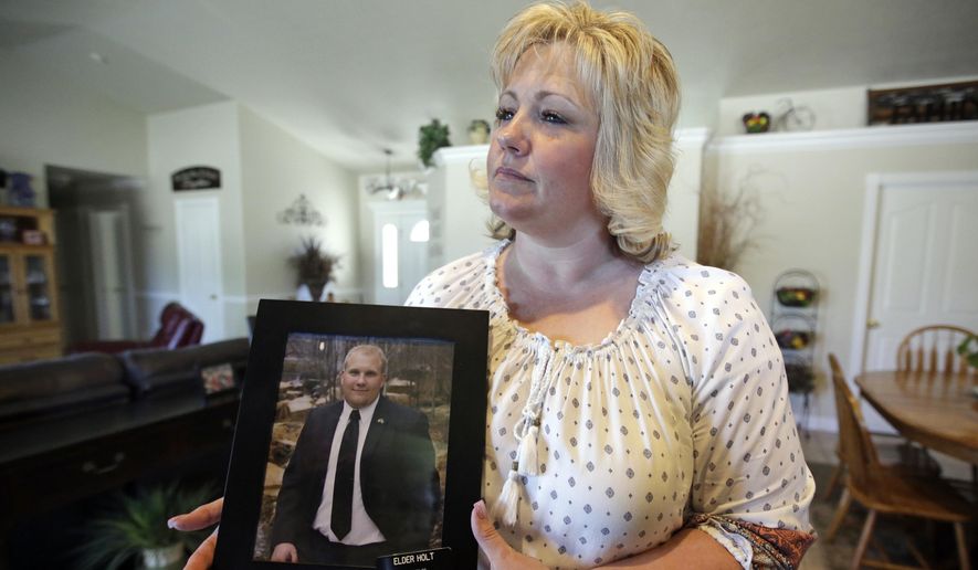 In this July 13, 2016, file photo, Laurie Holt holds a photograph of her son Joshua Holt at her home, in Riverton, Utah. A secret backchannel has opened up in 2018, between normally hostile Venezuelan and U.S. officials to discuss the possible release of Joshua Holt, jailed for more than 20 months in the volatile South American nation, multiple congressional sources have told the AP. (AP Photo/Rick Bowmer, File)