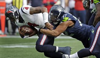 FILE - In this Oct. 29, 2017, file photo, Houston Texans quarterback Deshaun Watson (4) is sacked by Seattle Seahawks defensive end Michael Bennett in the first half of an NFL football game in Seattle. The Super Bowl champion Philadelphia Eagles have acquired three-time Pro Bowl defensive end Michael Bennett from the Seattle Seahawks, two people familiar with the trade told The Associated Press Wednesday, March 7, 2018. (AP Photo/Elaine Thompson, File) **FILE**