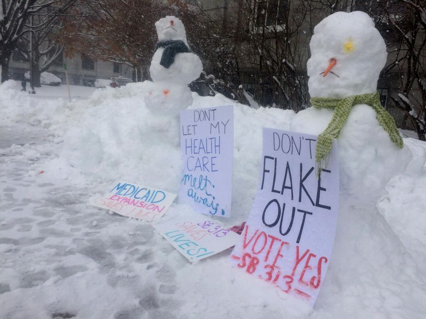 A pair of snowmen in Concord, New Hampshire, lobby the state Senate to pass a bill on Thursday, March 8, 2018, to reauthorize the state's expanded Medicaid program. The current program has put about 50,000 low-income residents on private insurance plans, but it will expire if lawmakers don't reauthorize it. (AP Photo/Holly Ramer)