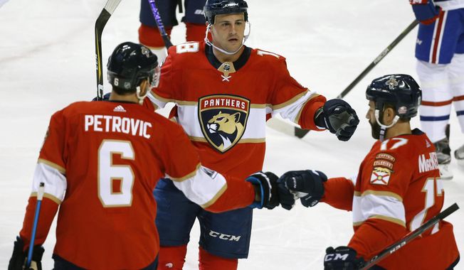 Florida Panthers center Micheal Haley, center, celebrates with defenseman Alexander Petrovic (6) and center Derek MacKenzie (17) after scoring during the second period of an NHL hockey game against the Montreal Canadiens, Thursday, March 8, 2018 in Sunrise, Fla. (AP Photo/Wilfredo Lee)