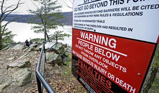 ADVANCE FOR USE SATURDAY, MARCH 10, AND THEREAFTER - In this Feb. 26, 2018 photo, a sign at the top of a Susquehanna River overlook warns visitors not to throw items from the vista because they might hit people using a section of the 14-mile Northwest Lancaster County River Trail below that opened in October 2016, in Chickies Rock County Park in Columbia, Pa. For private and public managers of natural areas working to keep natural landmarks open and accessible, yet safe for the public and uncluttered by signs and fences, the threat of liability is always in the background despite a Pennsylvania law aimed at protecting those who provide public recreation. (Blaine Shahan /LNP via AP)