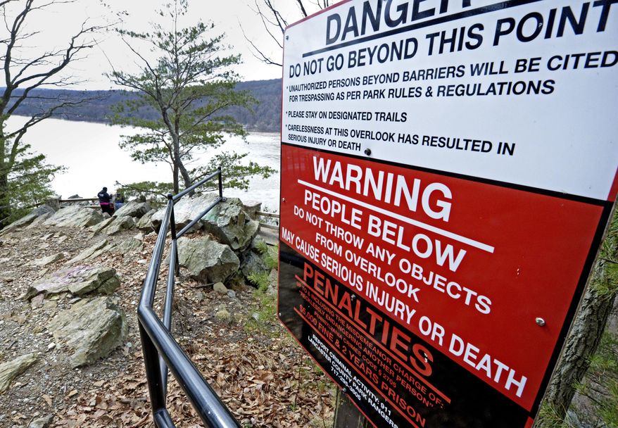 ADVANCE FOR USE SATURDAY, MARCH 10, AND THEREAFTER - In this Feb. 26, 2018 photo, a sign at the top of a Susquehanna River overlook warns visitors not to throw items from the vista because they might hit people using a section of the 14-mile Northwest Lancaster County River Trail below that opened in October 2016, in Chickies Rock County Park in Columbia, Pa. For private and public managers of natural areas working to keep natural landmarks open and accessible, yet safe for the public and uncluttered by signs and fences, the threat of liability is always in the background despite a Pennsylvania law aimed at protecting those who provide public recreation. (Blaine Shahan /LNP via AP)