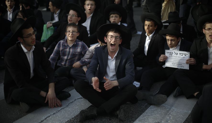 Ultra orthodox Jews block the entrance toJerusalem during a military draft protest, Thursday, March 8, 2018. Israel has compulsory military service for most Jewish men, but the ultra-Orthodox, whose political parties enjoy an outsized role in the country's coalition politics, have secured exemptions. Authorities still require ultra-Orthodox men to register for the draft, something to which the protesters gathered Thursday are opposed. (AP Photo/Ariel Schalit)