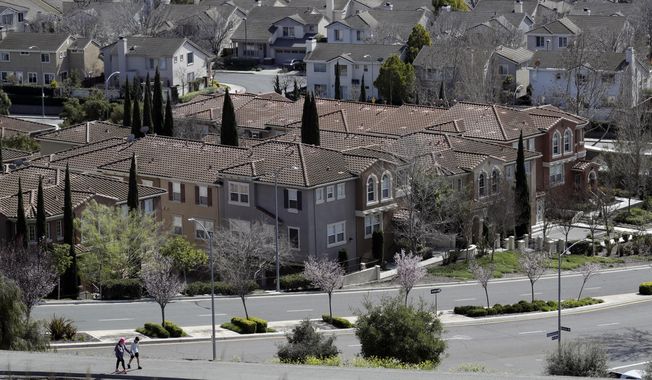 In this Tuesday, March 6, 2018, photo people walk along a path in front of a row of homes in San Jose, Calif. NerdWallet calculated affordability for 173 metropolitan areas by comparing the median annual household income and the monthly principal-and-interest payment for a median-priced single-family home and found that the least affordable homes are in the San Jose.(AP Photo/Marcio Jose Sanchez)