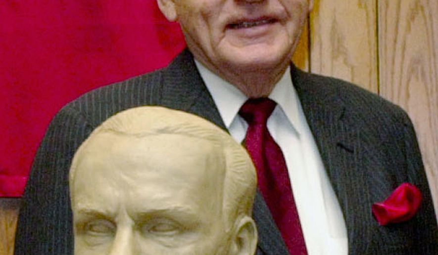 FILE - In this Feb. 22, 2003 file photo, former Neb. Governor, Charles Thone stands behind his clay bust in Lincoln, Neb., as the University of Nebraska-Lincoln College of Law paid tribute to five alumni governors. Thone, a former Nebraska governor and congressman who helped investigate the assassinations of President John F. Kennedy and Martin Luther King Jr., has died. He was 94. Thone's law partner and longtime friend, Mark Schorr, said Thone died Wednesday, March 7, 2018, of natural causes at his home in Lincoln. (AP Photo/Nati Harnik File)