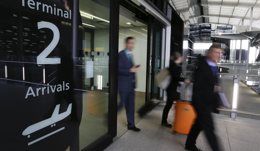 FILE- In this April 23, 2014, file photo, people pass an arrivals sign at the new Heathrow Airport Terminal 2 in London. Airfares to Europe this summer are expected to be slightly higher than last year, blame the rise in jet fuel prices, but that's an overall, average figure. On some routes, fares are running well below last year's prices. (AP Photo/Kirsty Wigglesworth, File)