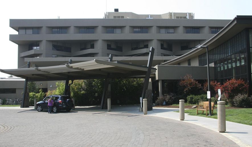 This 2014 photo shows the main entrance to St. Charles hospital in Bend, Ore. Officials from the Bend hospital say a sewage leak led them to cancel some surgeries and left patients without water to shower or use toilets for several hours. The Bulletin reports hospital staff discovered the leak Tuesday morning, March 6, 2018, in the central processing department where surgical instruments are cleaned and sterilized. (Andy Tullis/The Bulletin via AP)