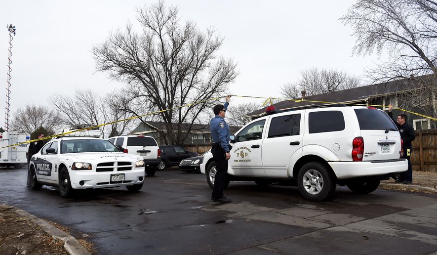 In a Tuesday, Feb. 6, 2018 photo, police help a Colorado Springs, Colo., Fire Department vehicle into the Murray Hill Apartments where El Paso County Sheriff deputy Micah Flick was killed while investigating a motor vehicle theft Monday, Feb. 5, 2018. (Dougal Brownlie/The Gazette via AP)