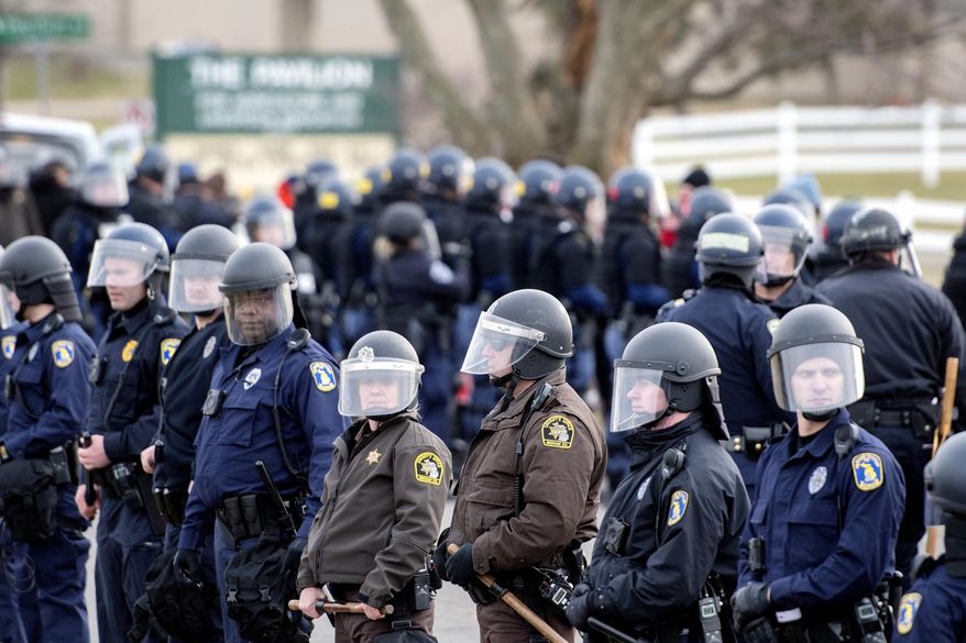 ADDS PHOTOGRAPHER'S NAME NICK KING - Police stand guard outside an event where white nationalist Richard Spencer was scheduled to speak, Monday, March 5, 2018, at Michigan State University in East Lansing, Mich. Police say at least a dozen people were arrested. Michigan State allowed Spencer to appear, but the venue was an auditorium at a remote end of campus. (Nick King/Lansing State Journal via AP)