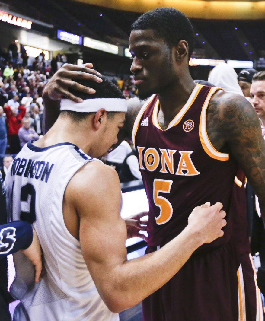 FILE - In this March 7, 2016, file photo, Iona guard A.J. English (5) embraces Monmouth guard Justin Robinson (12) after Iona's 79-76 win in an NCAA college basketball game for the championship of the Metro Atlantic Athletic Conference men's tournament in Albany, N.Y. Monmouth earned national recognition that season by beating UCLA and Notre Dame, but the Hawks lost in the conference tournament and went to the NIT. (AP Photo/Mike Groll, File)