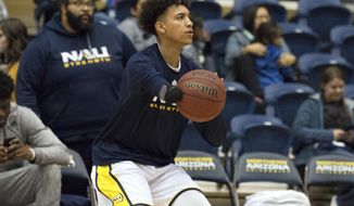 In this Jan. 18, 2018 photo provided by NAU Athletics, Northern Arizona&#39;s Omar Ndiaye warms up before an NCAA college basketball game against Eastern Washington in Flagstaff, Ariz. Ndiaye does not have a right hand due to a birth defect, but was still talented enough to become a Division I basketball player. (NAU Athletics vis AP)