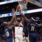 Washington Wizards forward Markieff Morris (5) goes to the basket between New Orleans Pelicans center Emeka Okafor (50) and guard Jrue Holiday (11) in the first half of an NBA basketball game in New Orleans, Friday, March 9, 2018. (AP Photo/Gerald Herbert)