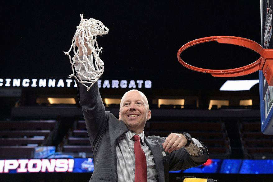 Cincinnati head coach Mick Cronin holds the net toward fans in the stands after cutting it down following a win over Houston in an NCAA college basketball championship game at the American Athletic Conference tournament Sunday, March 11, 2018, in Orlando, Fla. (AP Photo/Phelan M. Ebenhack)