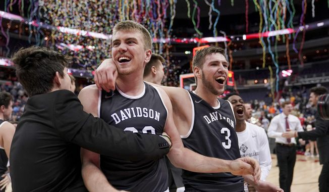 Davidson forward Peyton Aldridge (23), second from left, guard Jon Axel Gudmundsson (3), right, and others celebrate after an NCAA college basketball championship game against Rhode Island in the Atlantic 10 Conference tournament, Sunday, March 11, 2018, in Washington. (AP Photo/Andrew Harnik)