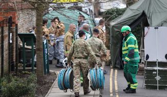 Military and emergency services personnel outside Bourne Hill police station in Salisbury, England, as police and members of the armed forces probe the suspected nerve agent attack on Russian double agent spy Sergei Skripal, Sunday March 11, 2018. British government security ministers held an emergency meeting Saturday to discuss the poisoning of former spy Skripal and his daughter Yulia, as police backed by soldiers continued to search the English town where he was attacked with a nerve agent. (Andrew Matthews/PA via AP)
