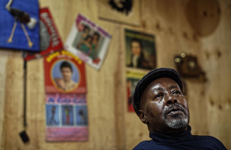 In this photo taken Thursday, March 1, 2018, James "Jimmy" Rugami sits inside his vinyl records stall in Kenyatta Market in Nairobi, Kenya. Tucked into a busy market in Kenya's capital is "Real Vinyl Guru", arguably the last record store still in operation in the country and which now enjoys the growing interest of music lovers who want to look beyond sleek digital offerings and return to the pleasure of browsing for a classic find. (AP Photo/Ben Curtis)
