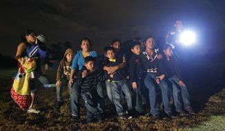 In this file photo, a group of immigrants from Honduras and El Salvador who crossed the U.S.-Mexico border illegally as they are stopped in Granjeno, Texas.  (AP Photo/Eric Gay, File) **FILE**