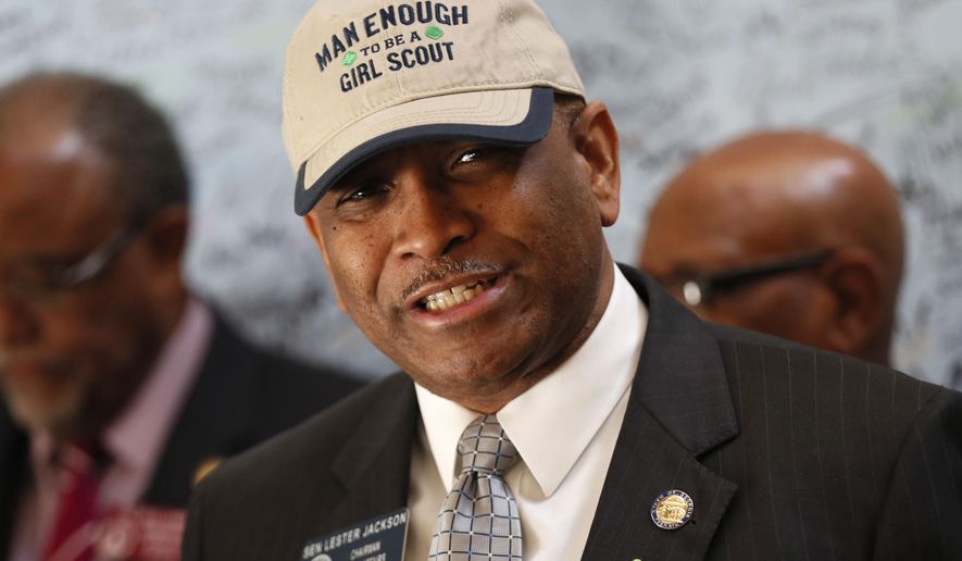 Senator Lester G. Jackson dons a cap supporting the Girl Scouts as he speaks at a press conference in Atlanta Monday,March 12, 2018, joined with other state legislators, where Girl Scouts presented more than 10,000 signatures that support renaming the Talmadge Memorial Bridge in Savanah after the Girl Scouts founder, Juliette Gordon Low. (Bob Andres/Atlanta Journal-Constitution via AP)
