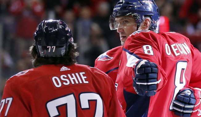 Washington Capitals left wing Alex Ovechkin (8) reaches to celebrate with right wing T.J. Oshie (77) after scoring in the first period of an NHL hockey game against the Winnipeg Jets, Monday, March 12, 2018, in Washington. (AP Photo/Alex Brandon)