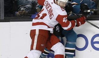 Detroit Red Wings&#39; Luke Glendening (41) presses San Jose Sharks&#39; Eric Fehr (16) against the boards during the second period of an NHL hockey game, Monday, March 12, 2018, in San Jose, Calif. (AP Photo/Marcio Jose Sanchez)