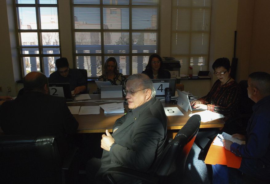 Democratic New Mexico state Rep. Tomas Salazar of Las Vegas, N.M., center, registers to run for re-election at the Secretary of State's Office in Santa Fe, N.M., Tuesday, March 13, 2018. Major-party candidates seeking election or re-election to the New Mexico House of Representatives, the state's utility-oversight commission and local judicial seats registered to run for office on Tuesday with state and county election regulators. (AP Photo/Morgan Lee)