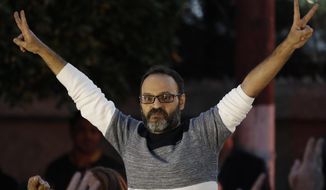 A Lebanese stage actor Ziad Itani, who was indicted on charges of collaborating with Israel and drug possession, flashes the victory signs after he was released by Lebanese authorities, on his arrival to his house, in Beirut, Lebanon, Tuesday, March 13, 2018. Itani was released on Tuesday and cleared of charges, while the officer who built the case against him was ordered detained. (AP Photo/Hussein Malla)