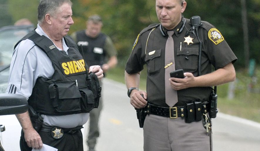 In this Sept. 27, 2017 photo, Isabella County Sheriff Michael Main, right, coordinates efforts in a police manhunt in rural Isabella County, Mich. Main is apologizing for accidentally leaving his gun in a mid-Michigan school gym locker room. Main said Tuesday, March 13, 2018 he takes full responsibility and is "devastated" by his own negligence. He says he was at a weekend event at Shepherd Middle School and used the locker room to change into uniform. (Lisa Yanick Litwiller /The Morning Sun via AP)