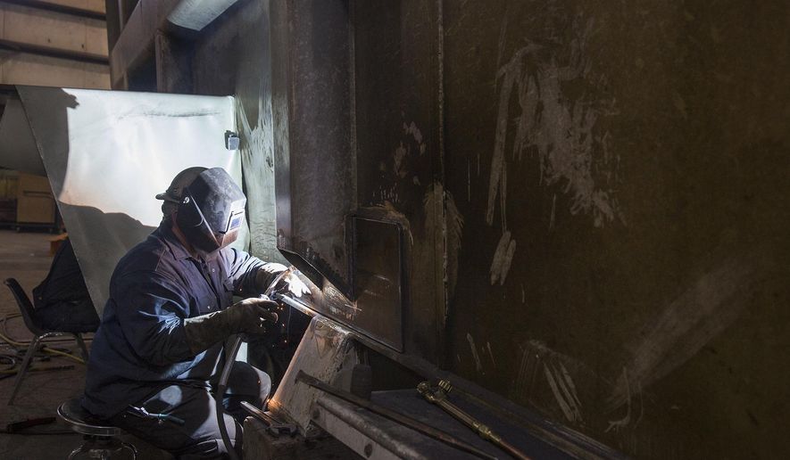 In this Feb. 22, 2018, photo, Wyatt Smith welds on a haul truck bed at L&H Industrial in Gillette, Wyo. (Kelly Wenzel/Gillette News Record via AP)