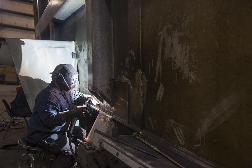 In this Feb. 22, 2018, photo, Wyatt Smith welds on a haul truck bed at L&H Industrial in Gillette, Wyo. (Kelly Wenzel/Gillette News Record via AP)