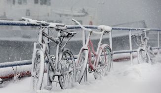 Bicycles are chained to a railing are covered with snow at the Boston Harbor Shipyard and Marina in Boston, Tuesday, March 13, 2018.  The National Weather Service issued a blizzard warning for much of the coast of Maine, New Hampshire, and Massachusetts.  (AP Photo/Michael Dwyer)
