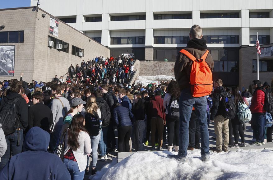 The Central High School student body file out of school as they participate in a student walkout Wednesday, March 14, 2018, in St. Paul, Minn. Students across the country participated in walkouts Wednesday to protest gun violence, one month after the deadly shooting inside a high school in Parkland, Fla. (AP Photo/Jim Mone)
