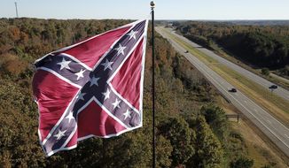 This Friday, Oct. 27, 2017 shows traffic flowing along the Route 58 bypass as a giant Confederate battle flag owned by flagger Robert Collie flutters in the breeze in Danville, Va. (AP Photo/Steve Helber)