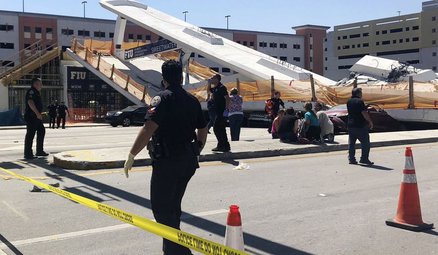 Emergency personnel work at the scene of a collapsed pedestrian bridge at Florida International University on Thursday, March 15, 2018, in the Miami area. The brand-new pedestrian bridge collapsed onto a highway crushing multiple vehicles and killing several people. (WTVJ NBC6 via AP)