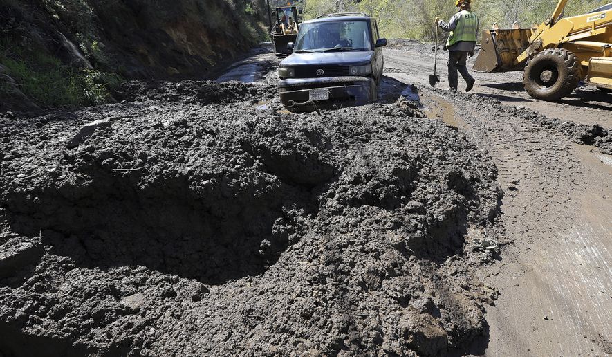 Workers prepare to free a trapped car from tons of debris after mudslides from heavy rain overnight caused the closure of Topanga Canyon Boulevard, a key mountain highway over the Santa Monica Mountains, above Malibu, Calif., early Thursday, March 15, 2018. No injuries were reported. The California Department of Transportation said that with more rain expected, the route through Topanga Canyon will remain closed through at least Sunday night. (AP Photo/Reed Saxon)