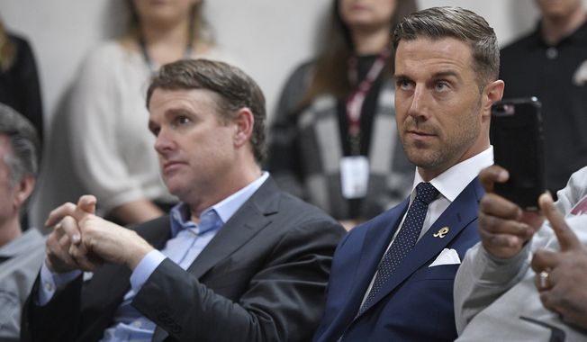 Newly signed Washington Redskins quarterback Alex Smith, right, and the NFL football team&#x27;s coach, Jay Gruden, left, listen during a news conference Thursday, March 15, 2018, in Ashburn, Va. (AP Photo/Nick Wass)