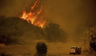 FILE - In this Dec. 9, 2017 file photo, a fire engine passes flames as a wildfire burns along Santa Ana Road near Ventura, Calif. Ranchers who lost cattle and property during California&#39;s largest-ever wildfire sued a utility on Thursday, March 15, 2018, for allegedly failing to maintain aging equipment and manage vegetation in areas where the blaze was sparked. The lawsuits filed in Ventura County claim Southern California Edison didn&#39;t mitigate the significant risk of wildfires stemming from its outdated equipment. (AP Photo/Noah Berge, Filer)
