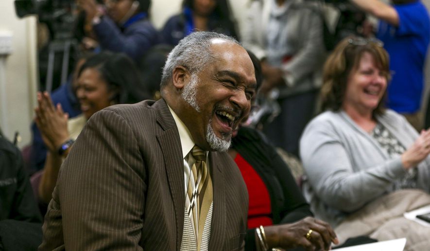 In this Wednesday, March 14, 2018 photo, Gregory Weatherspoon laughs after being named the new school interim superintendent at a special school board meeting at the Flint Community Schools Administrative Building, in Flint, Mich. (Henry Taylor /The Flint Journal-MLive.com via AP)